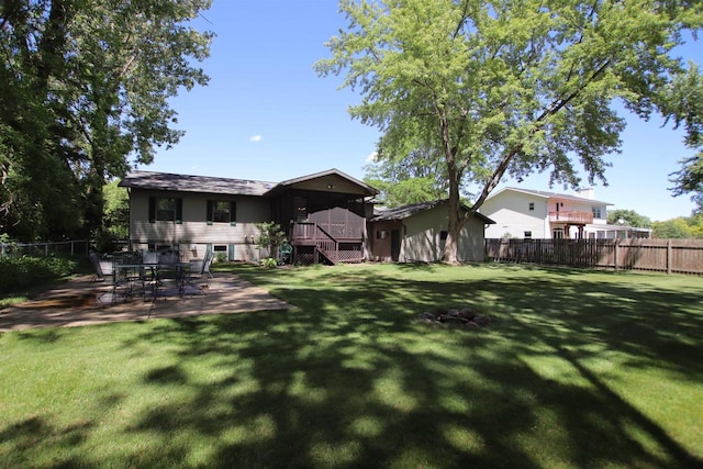 back of property featuring a wooden deck, a fire pit, a patio area, and a yard