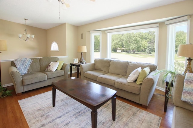 living room featuring wood-type flooring and ceiling fan with notable chandelier