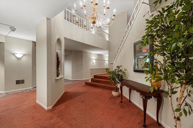 carpeted foyer entrance with a high ceiling and an inviting chandelier