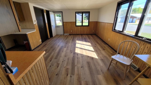 interior space with a drop ceiling, wooden walls, and dark wood-type flooring