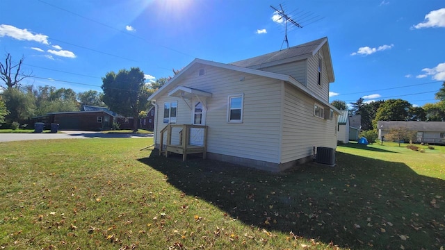 view of side of home with a lawn and cooling unit