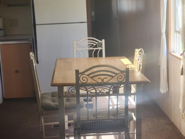 dining room featuring dark carpet