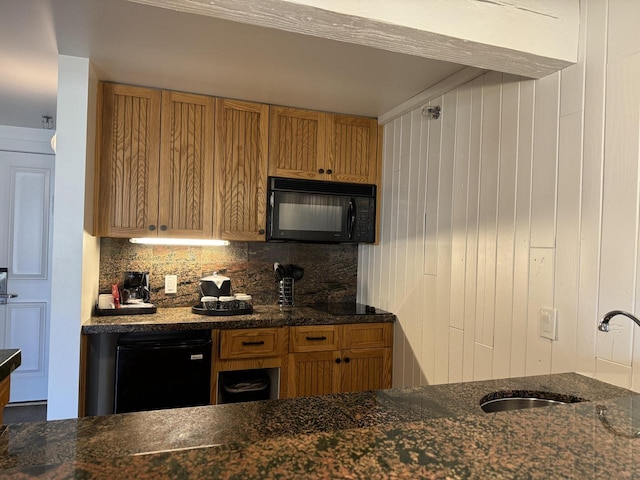 kitchen featuring backsplash, dark stone countertops, and sink