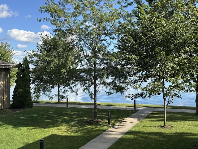 view of community with a lawn and a water view