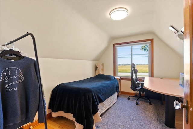 bedroom featuring lofted ceiling and hardwood / wood-style floors