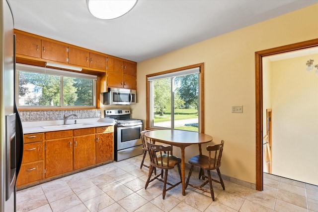 kitchen featuring appliances with stainless steel finishes, light tile patterned flooring, and sink