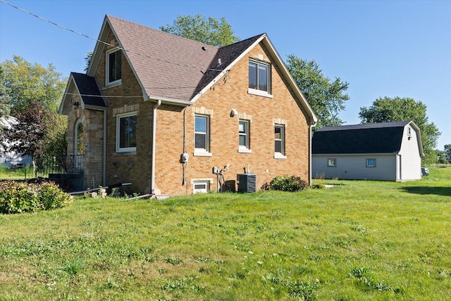 view of side of property with a yard and central AC