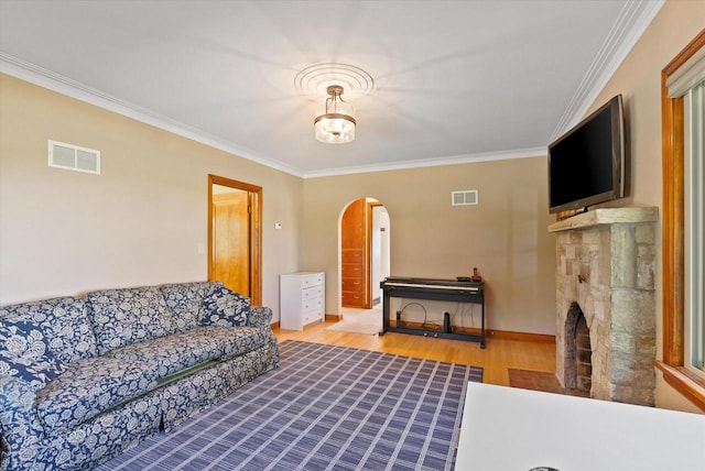 living room featuring wood-type flooring, a fireplace, and crown molding