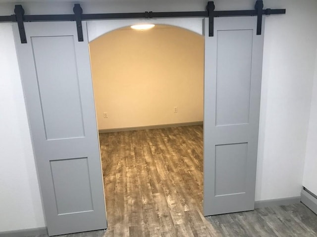 spare room featuring a barn door and hardwood / wood-style flooring