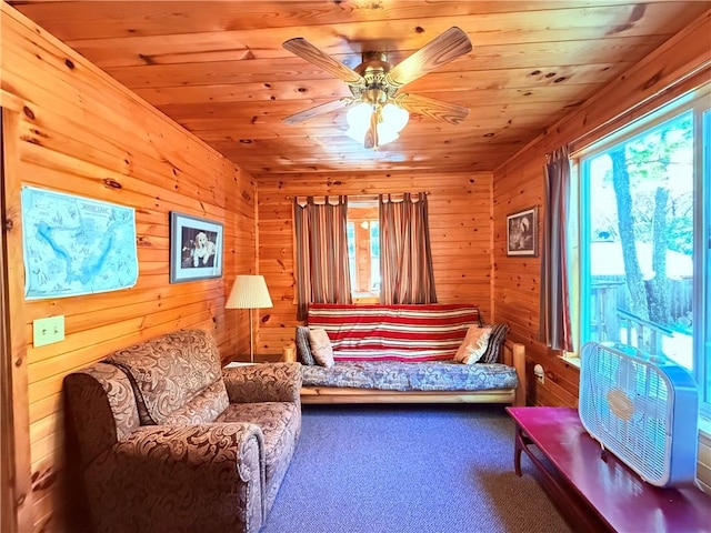 interior space featuring wooden walls, ceiling fan, wooden ceiling, and carpet floors