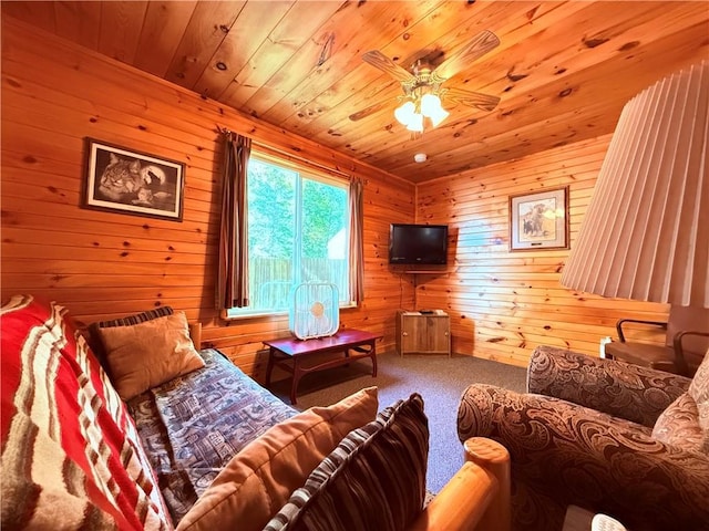 carpeted living room featuring ceiling fan, wooden walls, and wood ceiling