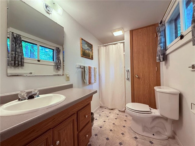 bathroom with curtained shower, vanity, and toilet