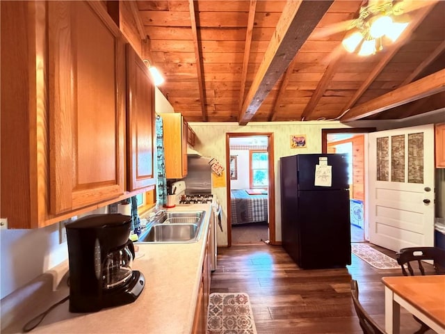 kitchen with vaulted ceiling with beams, black fridge, wood ceiling, wood walls, and dark hardwood / wood-style floors