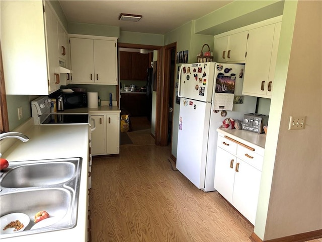 kitchen with white cabinets, exhaust hood, light hardwood / wood-style floors, white fridge, and sink