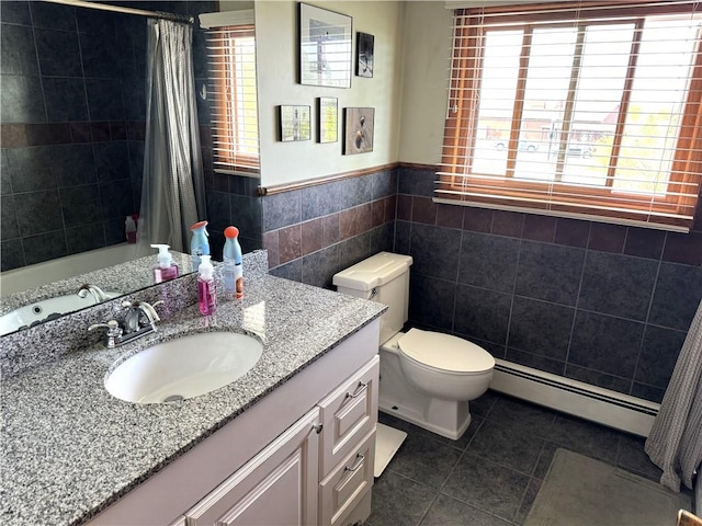 bathroom with tile patterned floors, toilet, a baseboard heating unit, vanity, and tile walls