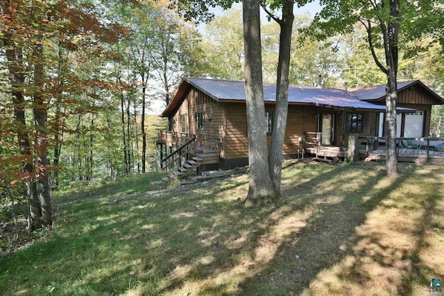 view of property exterior featuring a lawn and a deck