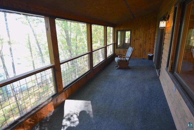 unfurnished sunroom featuring lofted ceiling and plenty of natural light