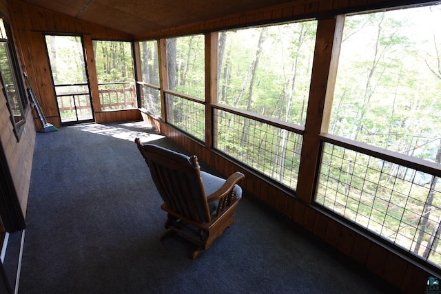 unfurnished sunroom featuring vaulted ceiling and a healthy amount of sunlight