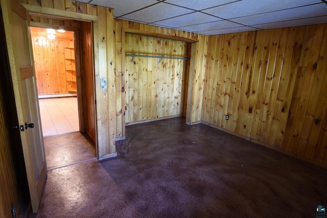 spare room featuring wood walls and a baseboard heating unit