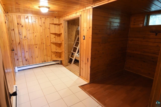 empty room with a baseboard heating unit, wooden walls, light tile patterned floors, and wood ceiling