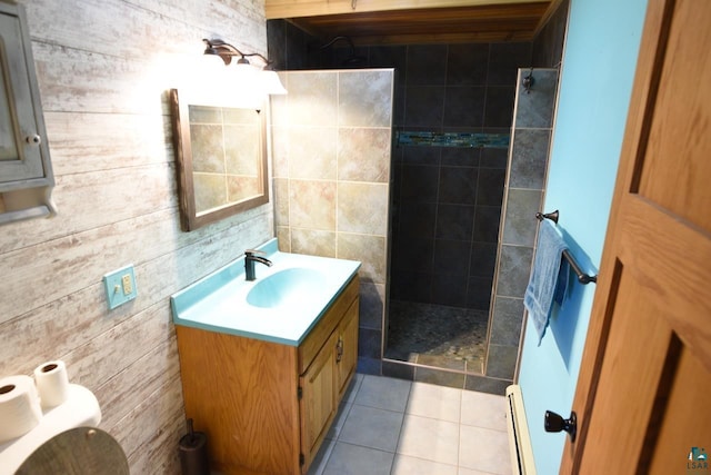 bathroom featuring a tile shower, a baseboard heating unit, tile patterned floors, vanity, and toilet