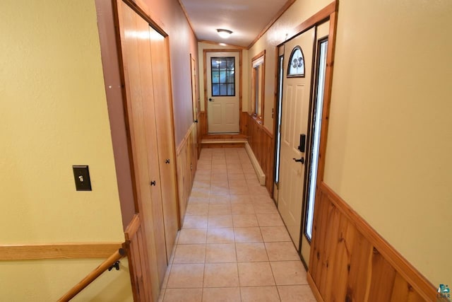 hallway featuring ornamental molding and light tile patterned floors