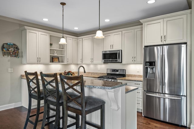 kitchen featuring dark stone counters, pendant lighting, dark wood-type flooring, a kitchen breakfast bar, and appliances with stainless steel finishes