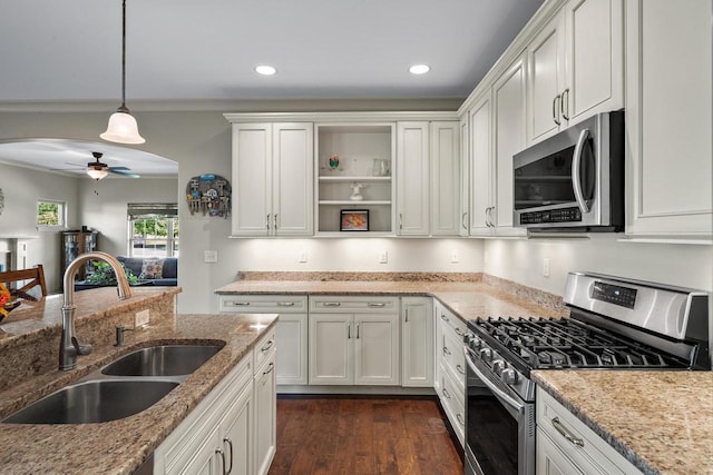 kitchen with stainless steel appliances, white cabinets, ceiling fan, and sink