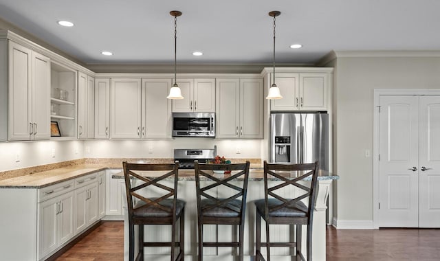 kitchen with appliances with stainless steel finishes, hanging light fixtures, light stone counters, a kitchen bar, and dark hardwood / wood-style floors