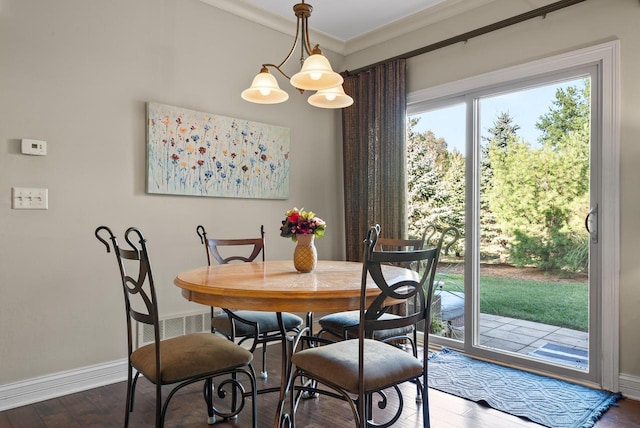 dining room with ornamental molding, an inviting chandelier, and dark wood-type flooring