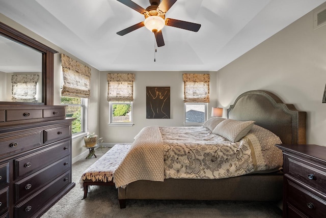 bedroom with ceiling fan, a raised ceiling, and carpet flooring