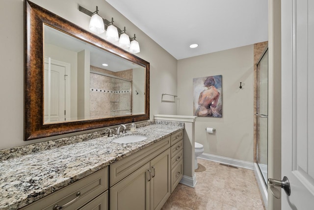 bathroom featuring vanity, toilet, and a shower with door