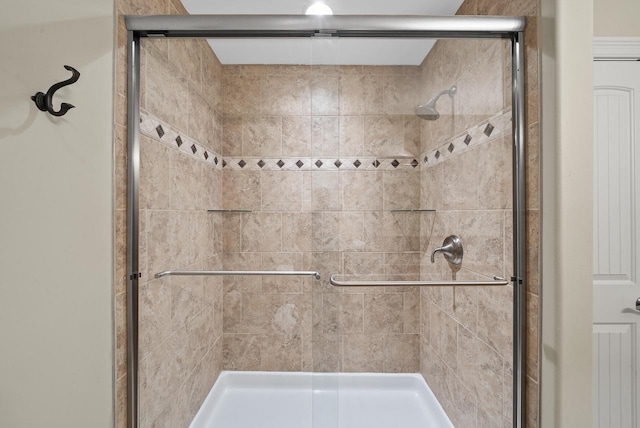 bathroom with a shower with door