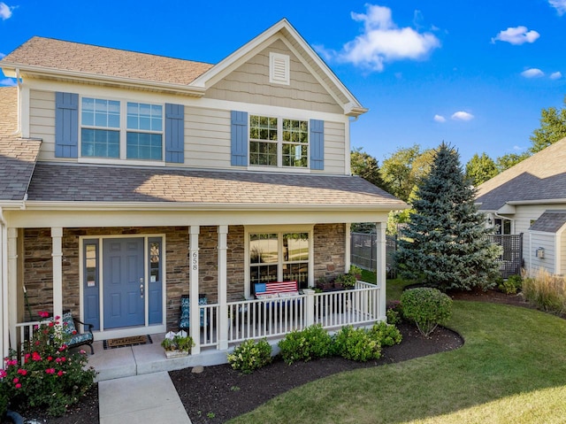 front facade with covered porch and a front yard