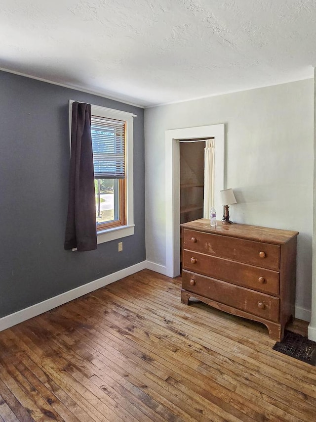 bedroom featuring a textured ceiling and wood-type flooring