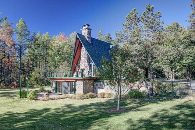 6147 County Rd E, Phelps, WI 54554 - rear view of house with a lawn, a chimney, a deck, and stone siding
