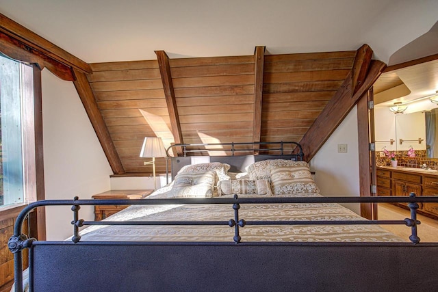 bedroom featuring vaulted ceiling with beams, sink, wood ceiling, and multiple windows