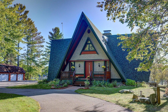 view of front of property featuring a garage, a front lawn, and a porch