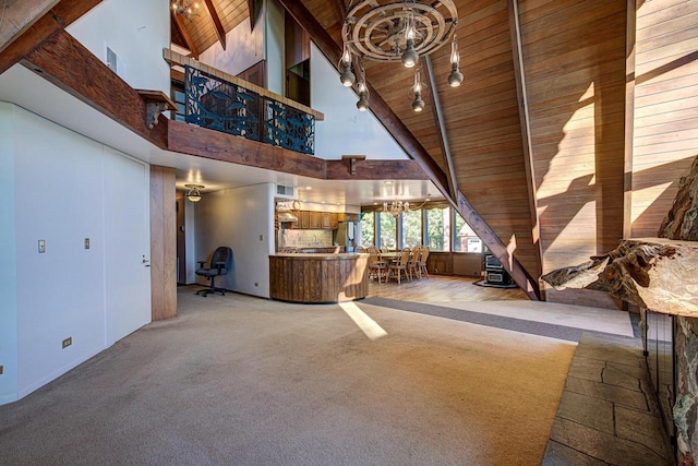 unfurnished living room featuring high vaulted ceiling, beamed ceiling, and an inviting chandelier