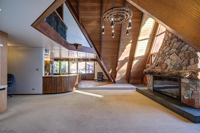 unfurnished living room with wood ceiling, carpet, a chandelier, high vaulted ceiling, and a fireplace