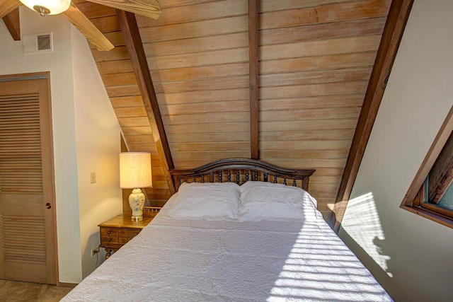 carpeted bedroom with ceiling fan, vaulted ceiling with beams, and wood ceiling