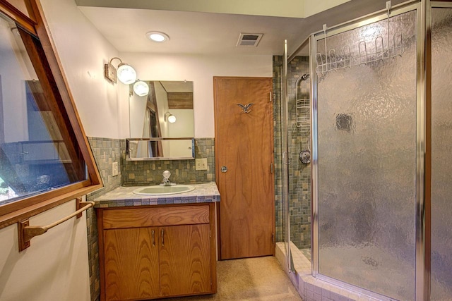 bathroom featuring vanity, decorative backsplash, and an enclosed shower