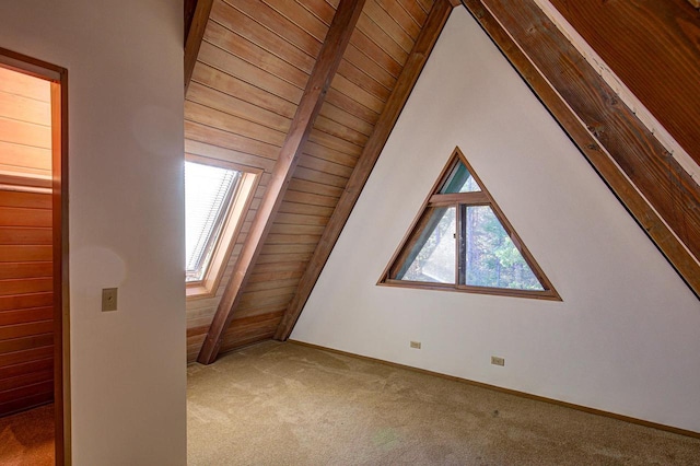 additional living space with wood ceiling, lofted ceiling with beams, carpet, and plenty of natural light