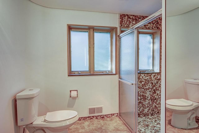 bathroom featuring toilet, walk in shower, and tile patterned floors