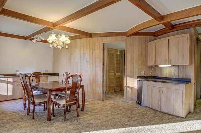 dining room featuring beam ceiling, a notable chandelier, wooden walls, and light colored carpet