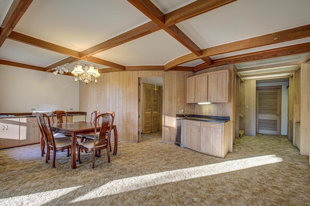 kitchen featuring an inviting chandelier, beam ceiling, wooden walls, and light brown cabinetry