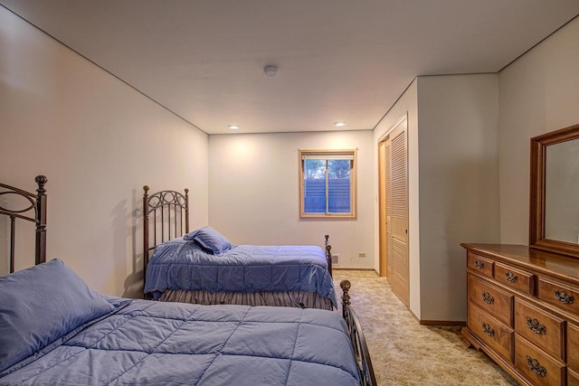 bedroom featuring a closet and light colored carpet