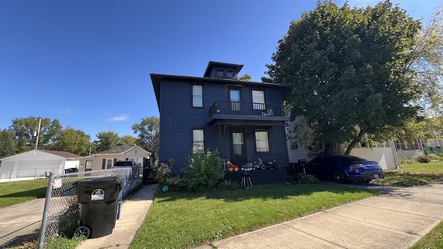 view of front of property with a balcony and a front lawn