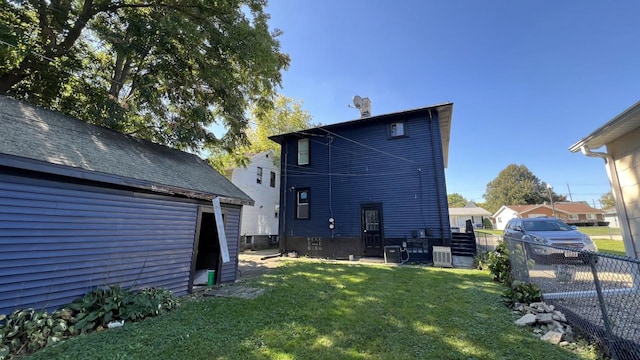 rear view of property featuring a yard and cooling unit