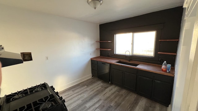 kitchen with hardwood / wood-style floors, wood counters, sink, and black dishwasher